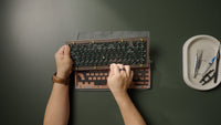Hold the top case in one hand while connecting the daughterboard cable with the other.