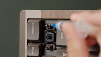 Injecting lube around the stabilizer wire with the keycap removed.