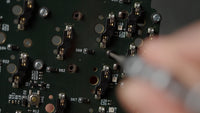While holding a standoff on the front of the PCB, secure it with a button head fastener on the back of the PCB.
